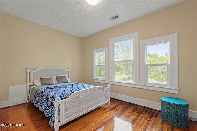 bedroom with hardwood / wood-style flooring and a textured ceiling