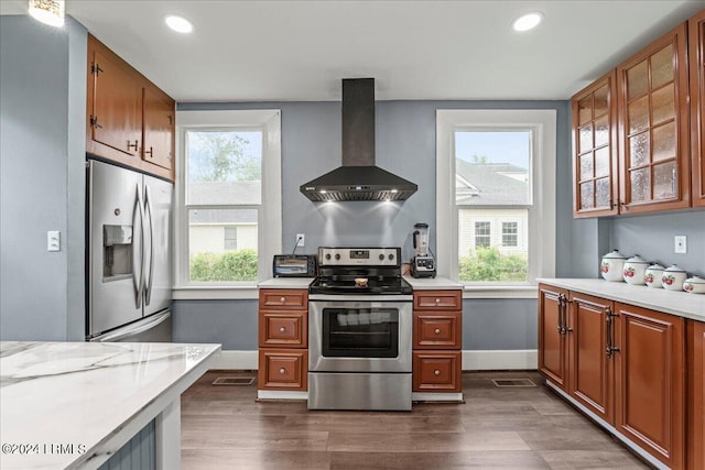 kitchen with light stone counters, island exhaust hood, dark hardwood / wood-style floors, and appliances with stainless steel finishes