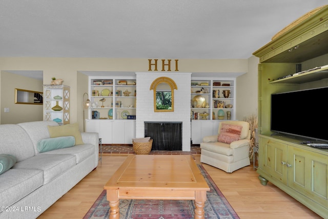 living room with light hardwood / wood-style flooring, a fireplace, and built in features