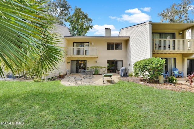 rear view of house featuring a lawn and a patio area