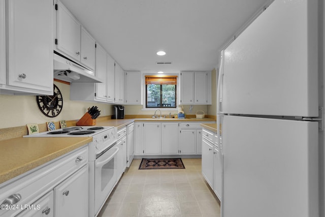 kitchen with white appliances, sink, and white cabinets