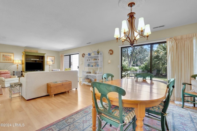 dining area featuring an inviting chandelier and light wood-type flooring