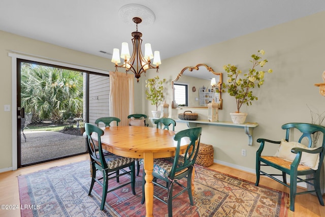 dining room with an inviting chandelier and light hardwood / wood-style flooring