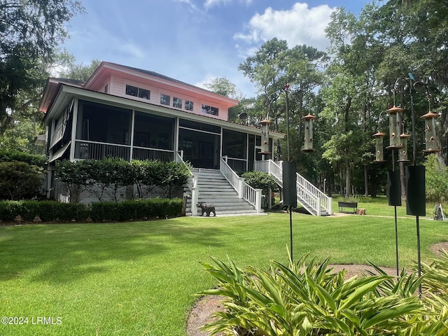 view of front of house with a front yard and a sunroom