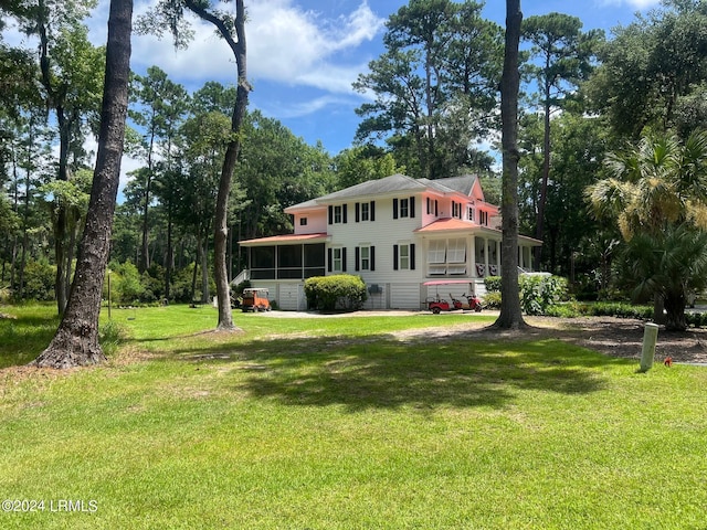 view of front facade featuring a front yard and a sunroom