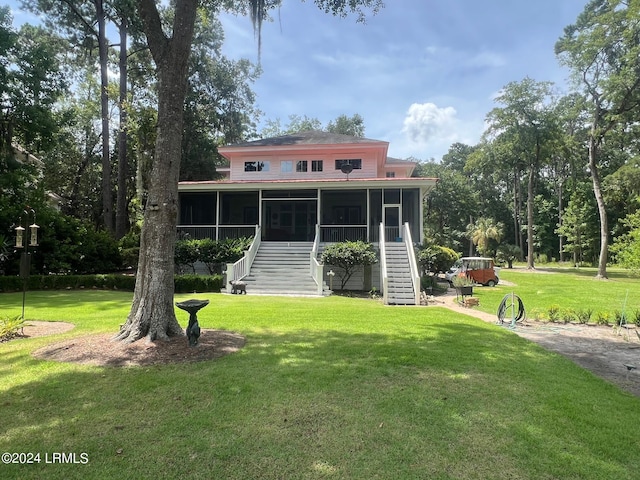 back of property featuring a yard and a sunroom