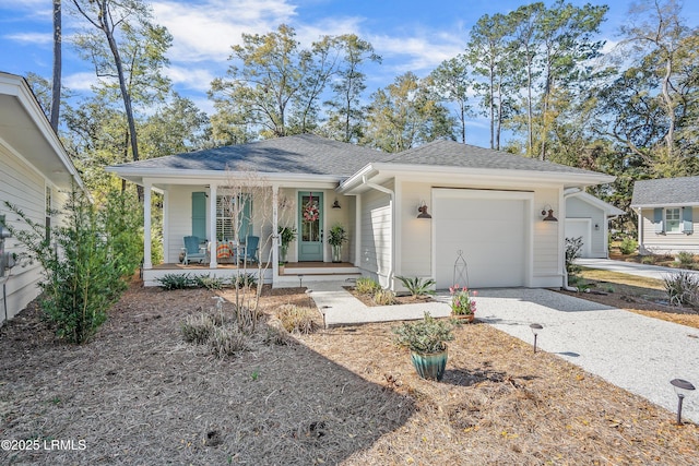 view of front of property with driveway, roof with shingles, covered porch, and an attached garage