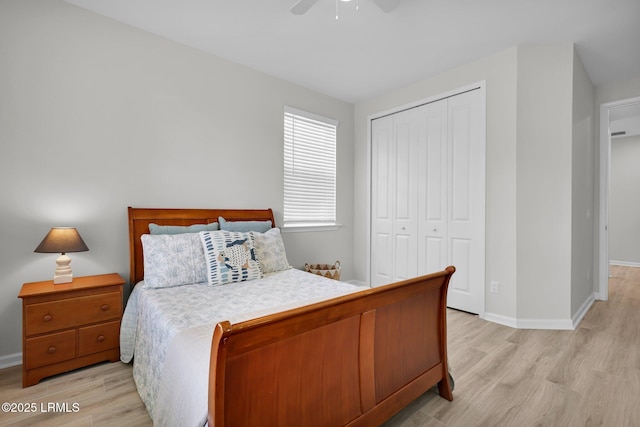 bedroom with baseboards, a closet, light wood-style floors, and ceiling fan