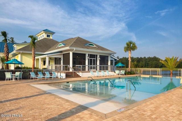 community pool featuring fence, a sunroom, and a patio area