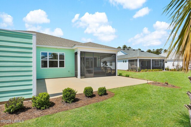 rear view of property with a sunroom, a shingled roof, a yard, and a patio