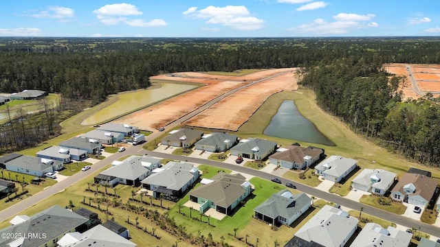 bird's eye view with a water view, a residential view, and a wooded view