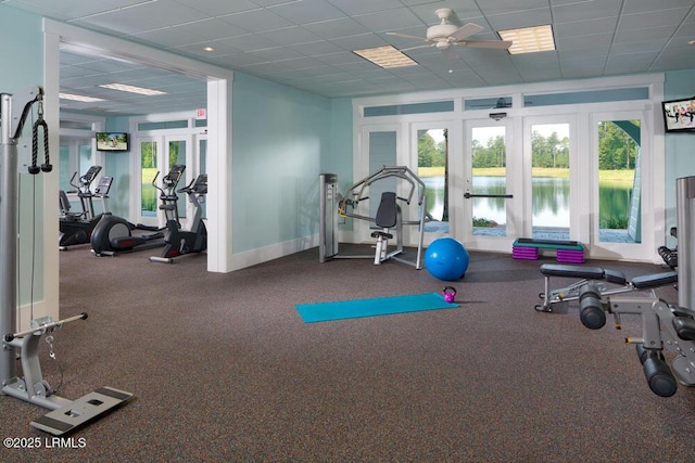 gym with french doors, a drop ceiling, and ceiling fan