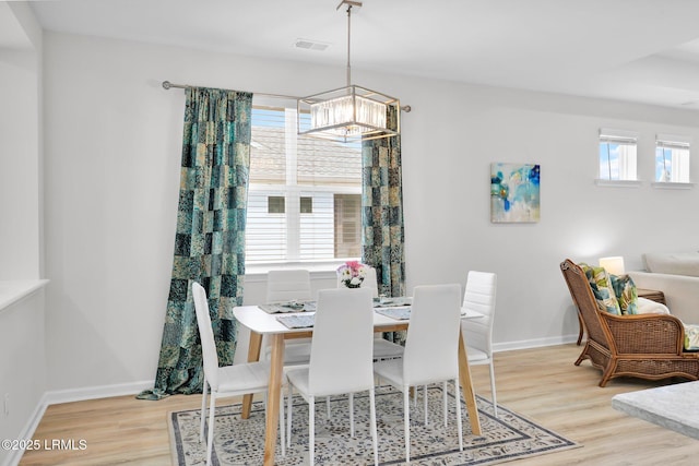 dining room with baseboards, visible vents, a chandelier, and light wood-type flooring