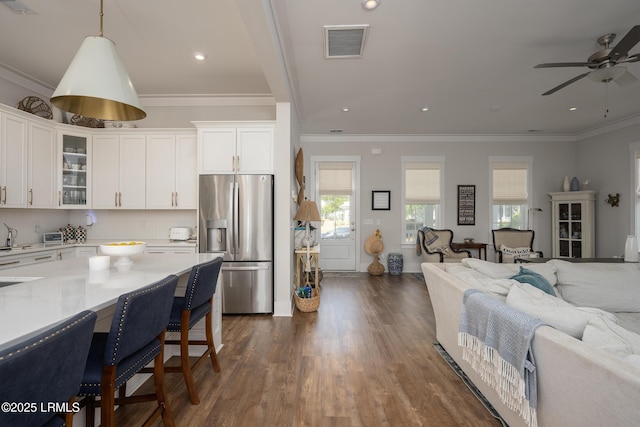 kitchen with a ceiling fan, dark wood-style flooring, visible vents, stainless steel fridge with ice dispenser, and open floor plan