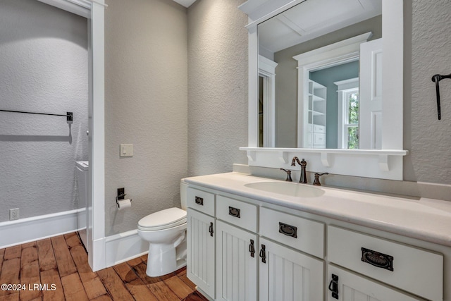 bathroom with wood-type flooring, toilet, and vanity