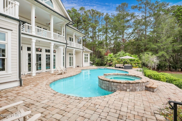 view of swimming pool with french doors, a patio, ceiling fan, and an in ground hot tub