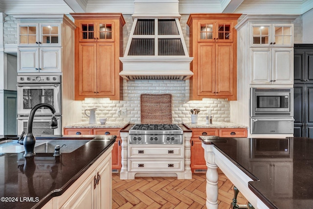 kitchen with tasteful backsplash, light parquet flooring, appliances with stainless steel finishes, and custom range hood