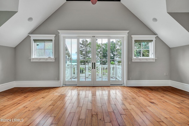 bonus room with light hardwood / wood-style floors and french doors