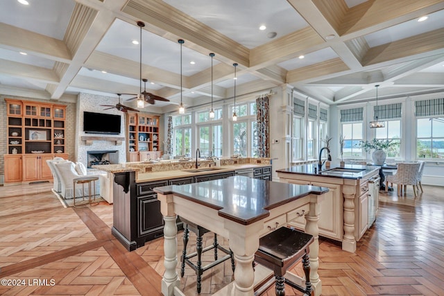 kitchen featuring a large island with sink, light parquet floors, a kitchen bar, and decorative light fixtures