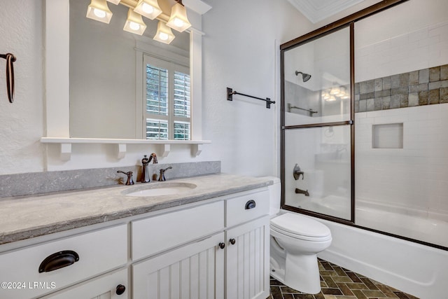 full bathroom with enclosed tub / shower combo, vanity, crown molding, and toilet