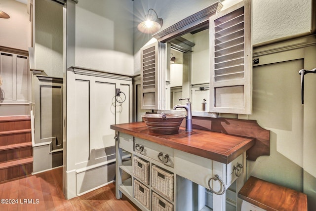 kitchen with wood counters, wood-type flooring, and sink