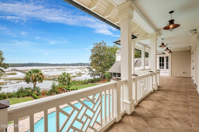 balcony with a water view and ceiling fan