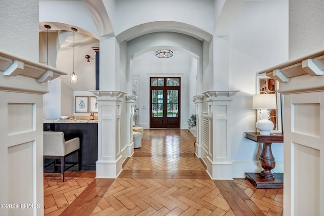 entryway featuring a high ceiling, light parquet flooring, and french doors