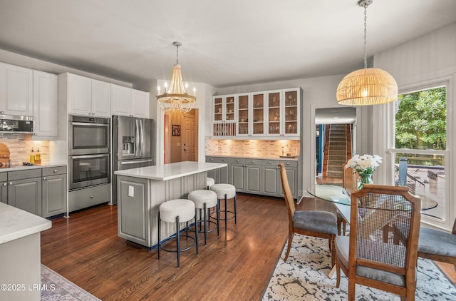 70 Dolphin Point Dr, Beaufort, SC 29907 - kitchen featuring appliances with stainless steel finishes, a chandelier, backsplash, a center island, and glass insert cabinets