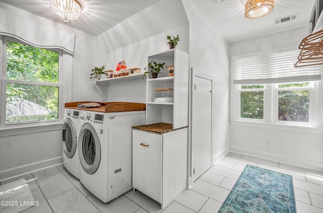 70 Dolphin Point Dr, Beaufort, SC 29907 - laundry room featuring independent washer and dryer, a chandelier, and cabinet space