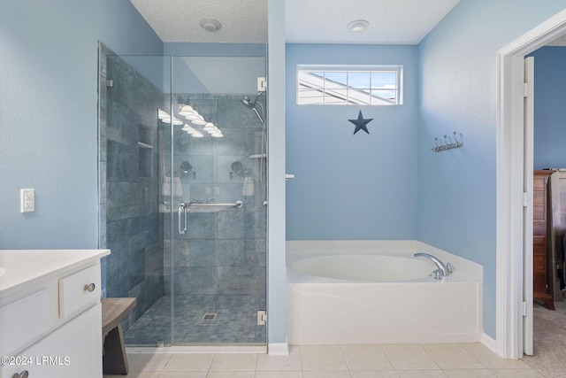 full bath with tile patterned floors, a garden tub, a stall shower, a textured ceiling, and vanity