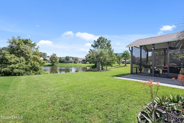 view of yard featuring a patio area, a sunroom, and a water view