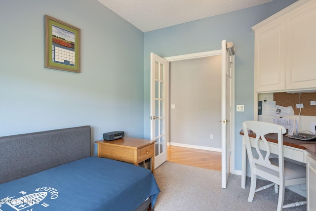 bedroom featuring light carpet, a textured ceiling, and french doors