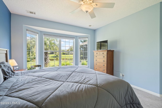 bedroom with a ceiling fan, baseboards, visible vents, a textured ceiling, and carpet flooring