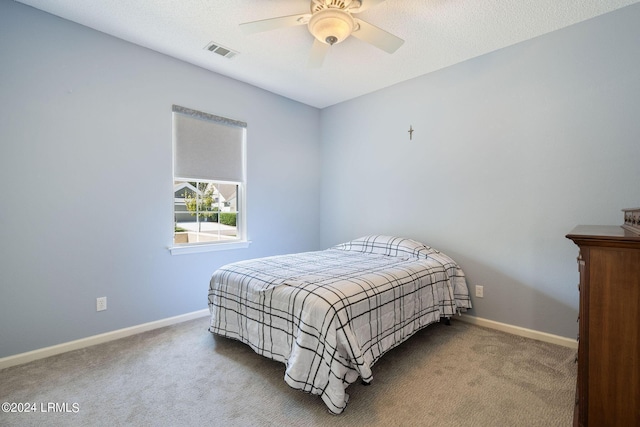 carpeted bedroom featuring visible vents, baseboards, a textured ceiling, and ceiling fan