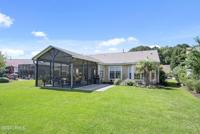 rear view of house with a lanai, a lawn, and a patio