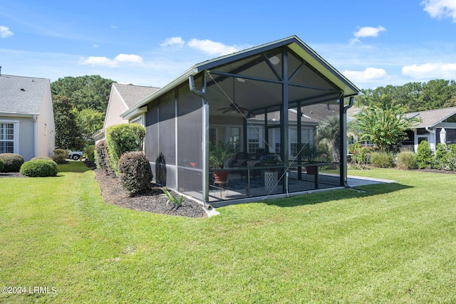 rear view of house with a lawn and a sunroom