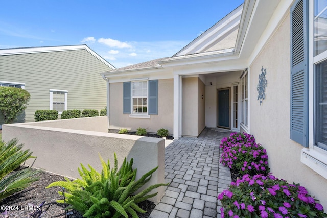 property entrance featuring a patio area and stucco siding