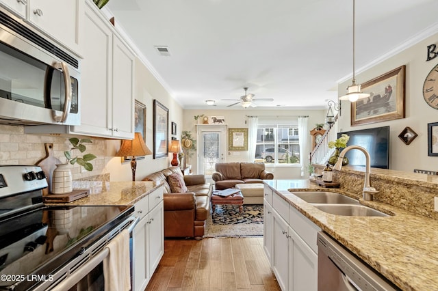 kitchen with crown molding, visible vents, appliances with stainless steel finishes, and a sink