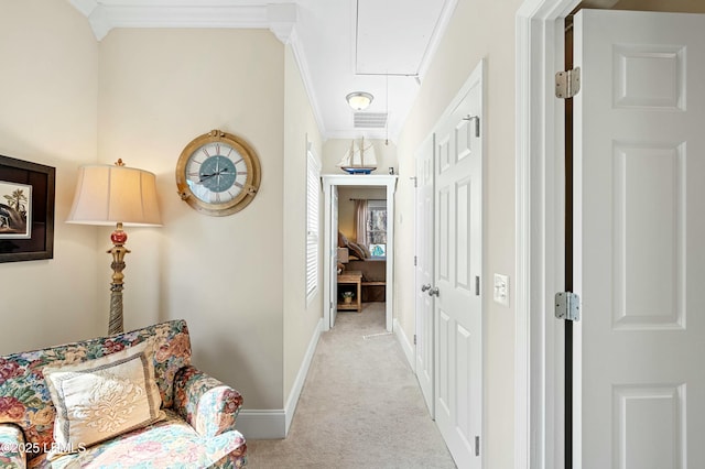 corridor featuring visible vents, baseboards, ornamental molding, carpet, and attic access