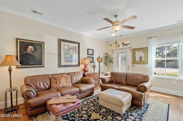 living area with a healthy amount of sunlight, visible vents, crown molding, and wood finished floors