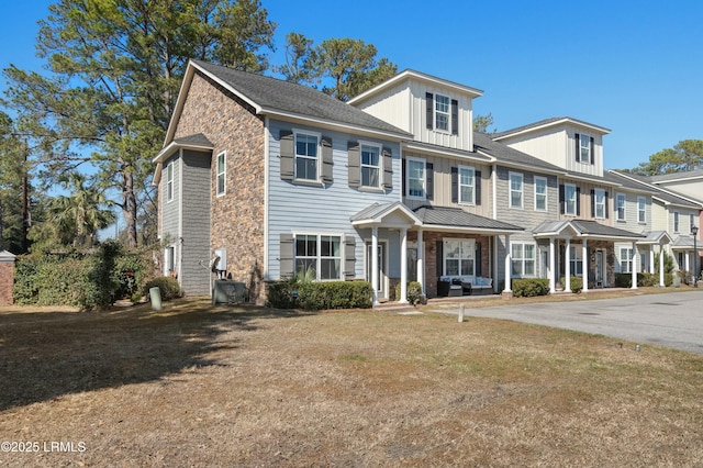 multi unit property with board and batten siding and a front yard