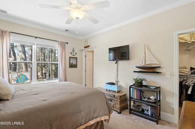 carpeted bedroom with a closet, crown molding, a spacious closet, and ceiling fan