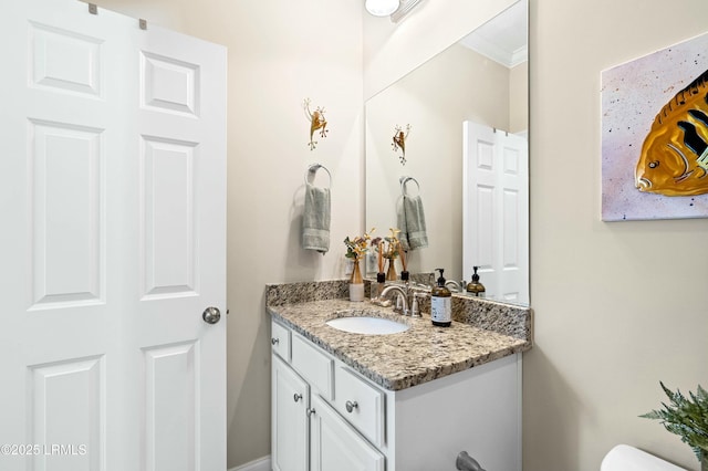 bathroom featuring toilet, crown molding, and vanity