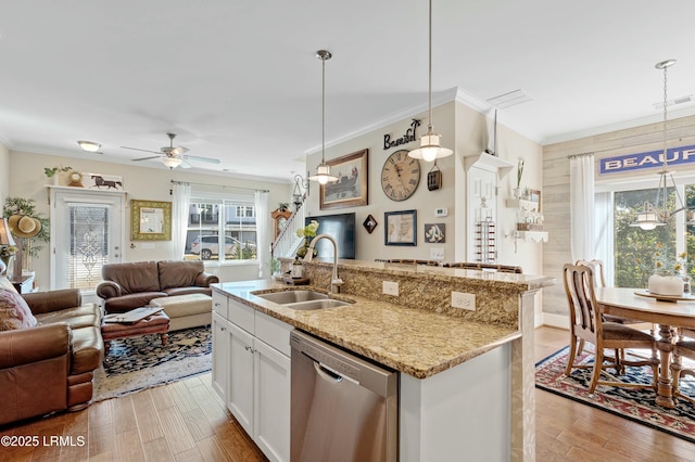 kitchen with light wood finished floors, visible vents, open floor plan, stainless steel dishwasher, and a sink