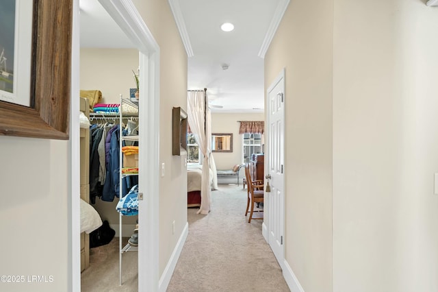 hall featuring baseboards, ornamental molding, recessed lighting, and light colored carpet