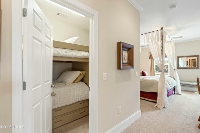 bedroom featuring carpet floors, visible vents, crown molding, and baseboards