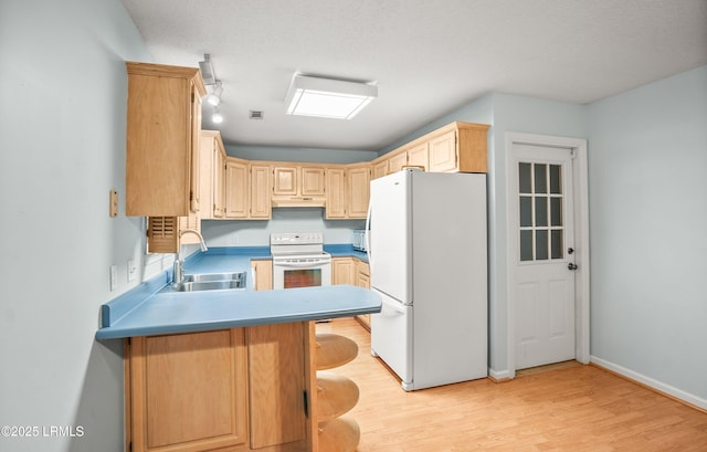 28 Walnut Hill St, Beaufort, SC 29907 - kitchen with white appliances, a sink, a peninsula, light brown cabinets, and light wood-type flooring