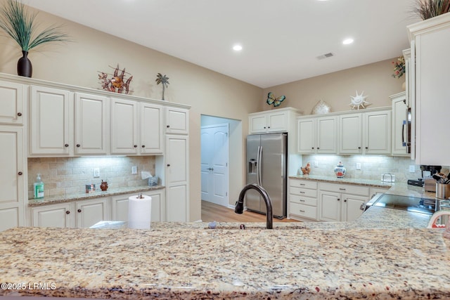 kitchen with decorative backsplash, stainless steel appliances, and white cabinets