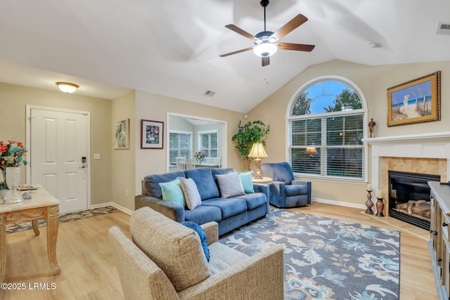 living room featuring lofted ceiling, light hardwood / wood-style flooring, and ceiling fan