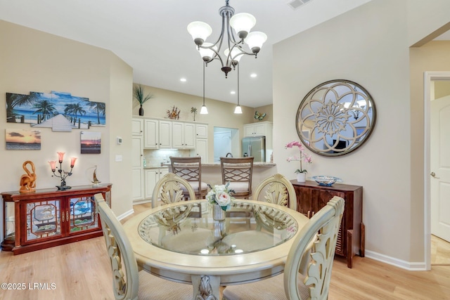 dining room featuring a notable chandelier and light wood-type flooring